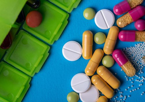 top-view-with-green-organizer-from-which-he-poured-pills-multicolored-capsules-green-white-colors